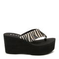 Side view of the Rocket Dog Crush tan animal print flip flop, animal print strap on a black wedge platform