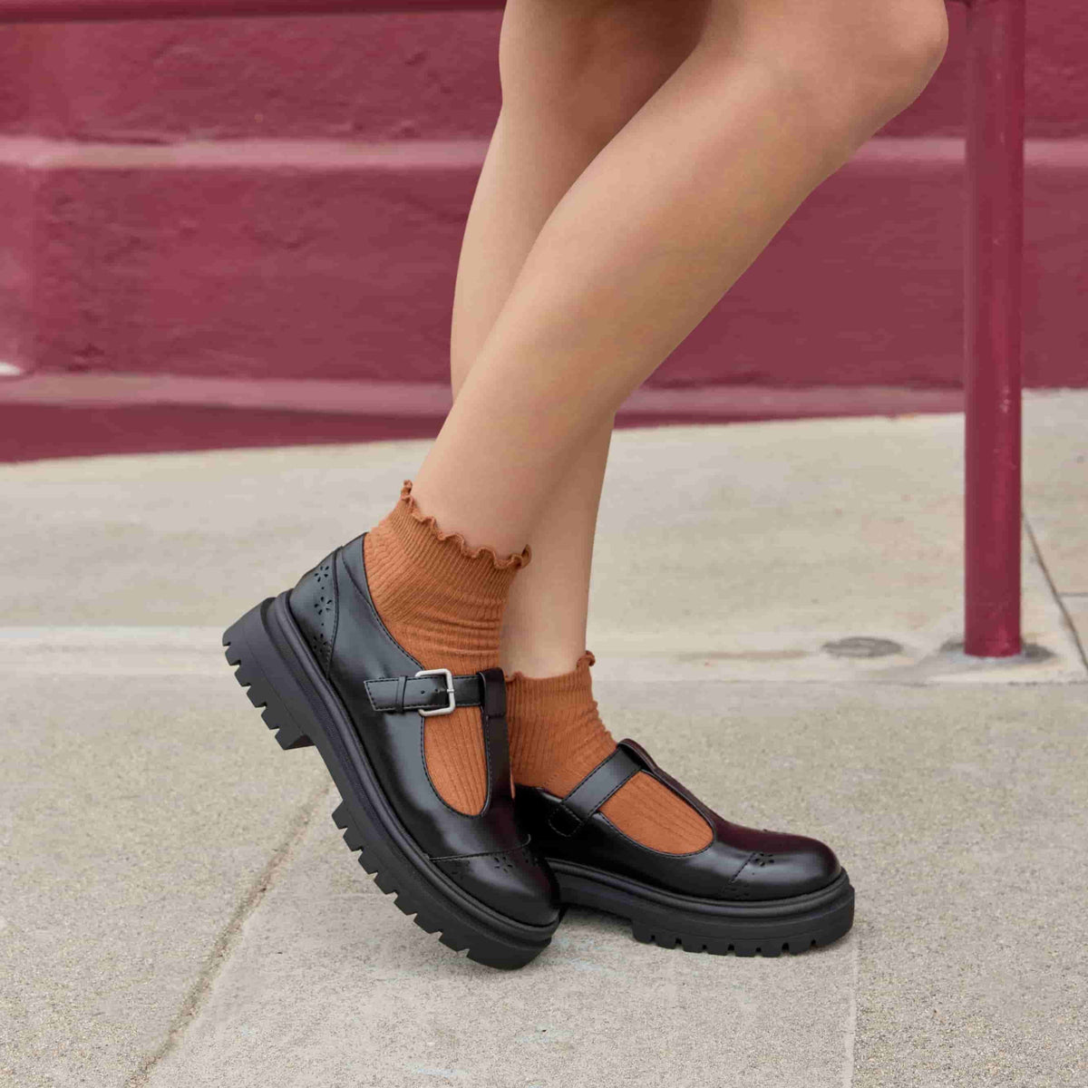 Image 3: Dalma Black Chunky Mary Jane Shoes in black worn with ankle socks, lifestyle side view showing chunky sole and T-bar shape