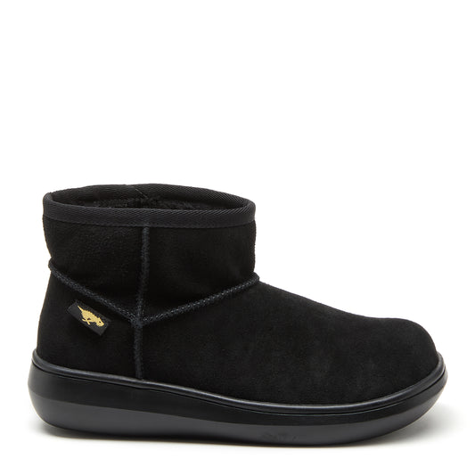 A black suede ankle boot with a faux shearling lining, featuring a low heel and slip-on style.
